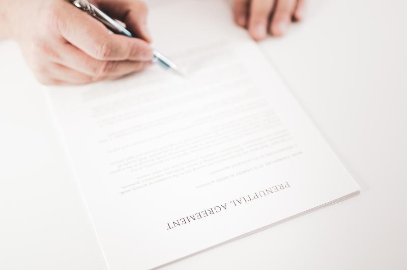 Close-Up View of a Person Signing a Prenuptial Agreement Document with a Pen in Treasure Coast, FL